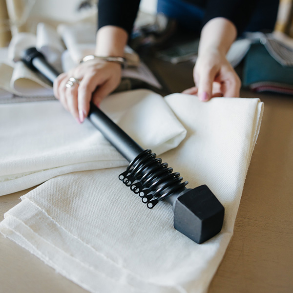 Hands arranging white fabric on a table